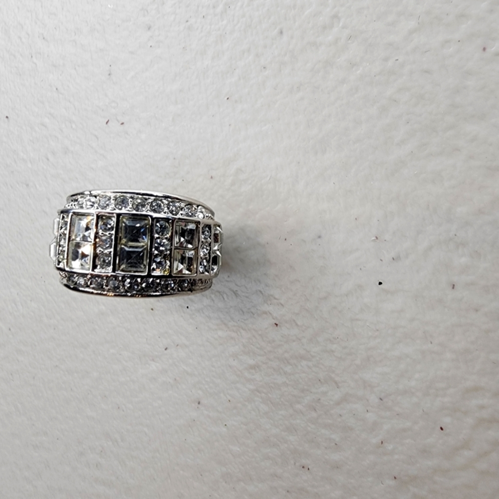 Designer band in silver with cubic zirconia stones throughout. Size 5 EUC.